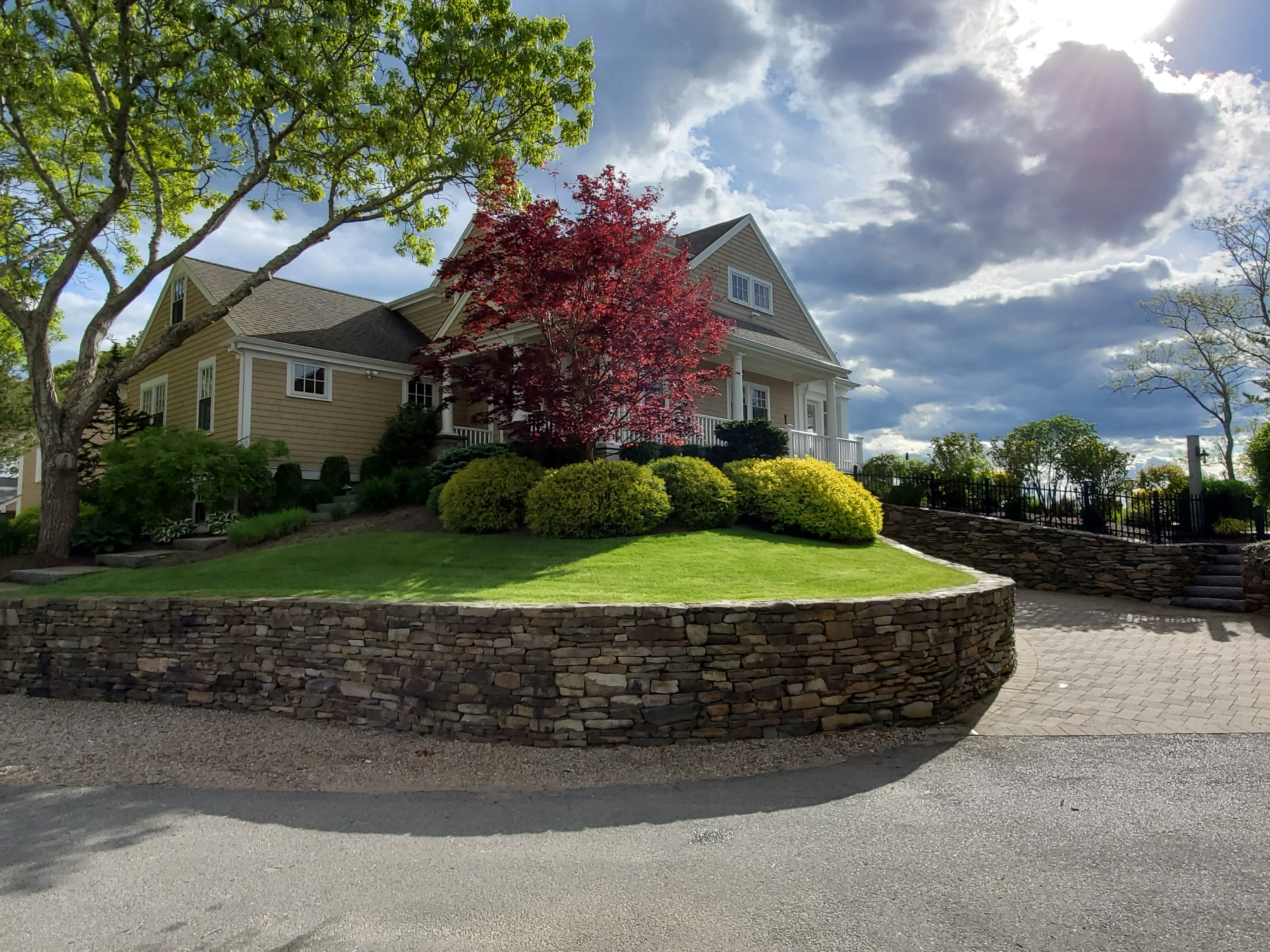 Waterfront property with lush green lawn and stone retaining wall