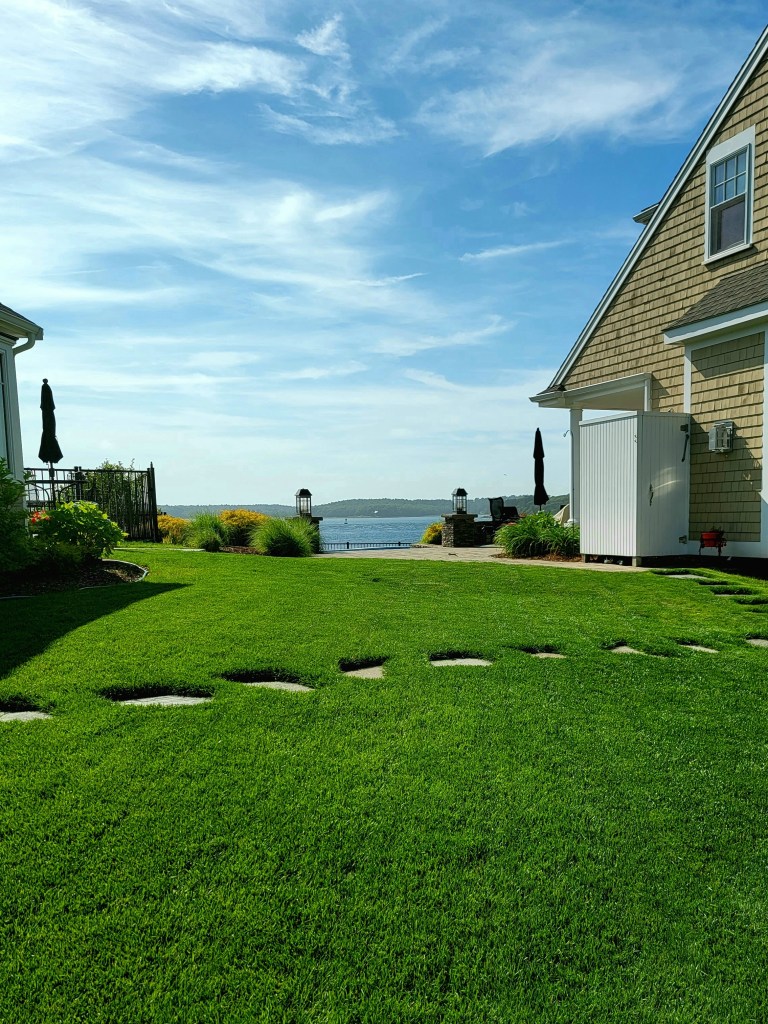 Waterfront lawn with stepping stones and water view
